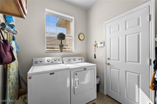 clothes washing area featuring washing machine and dryer, light tile patterned floors, and cabinets