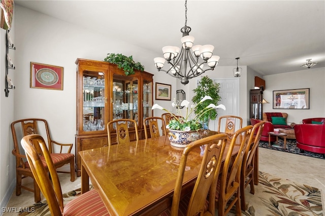 dining space with an inviting chandelier and light colored carpet