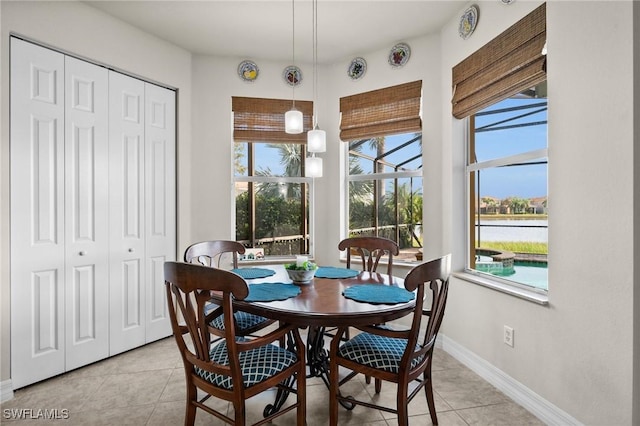 11309 Pond Cypress St, Fort Myers, FL 33913 - dining room featuring light tile patterned flooring, baseboards, and a water view