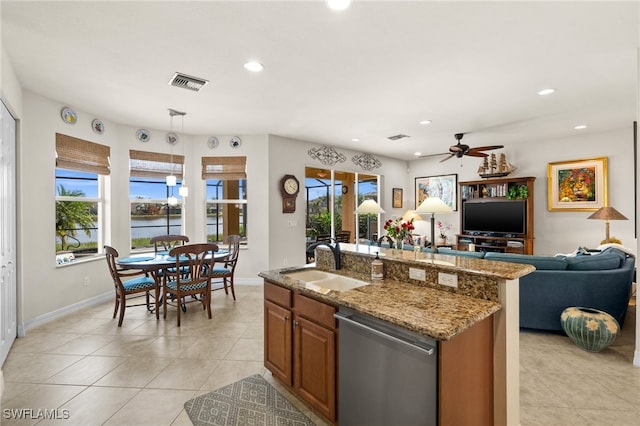 kitchen featuring a center island with sink, a healthy amount of sunlight, stainless steel dishwasher, and sink