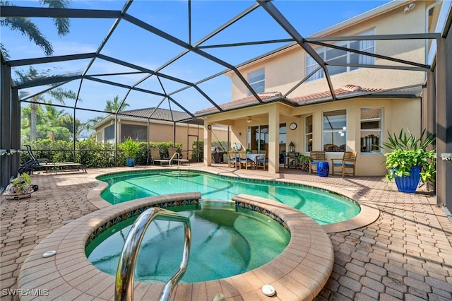 view of swimming pool featuring an outdoor hangout area, ceiling fan, glass enclosure, a patio, and an in ground hot tub