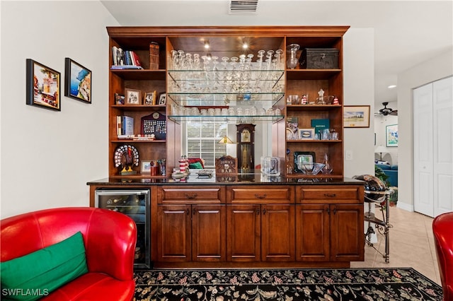 bar with ceiling fan, light tile patterned floors, and beverage cooler