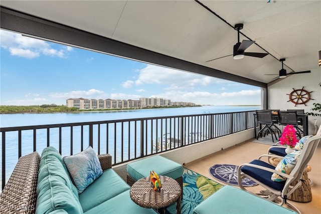 balcony with ceiling fan, a water view, and an outdoor hangout area