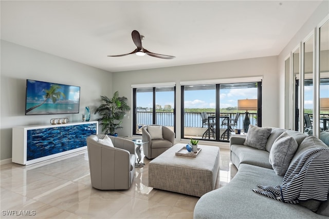 living room with ceiling fan and a water view