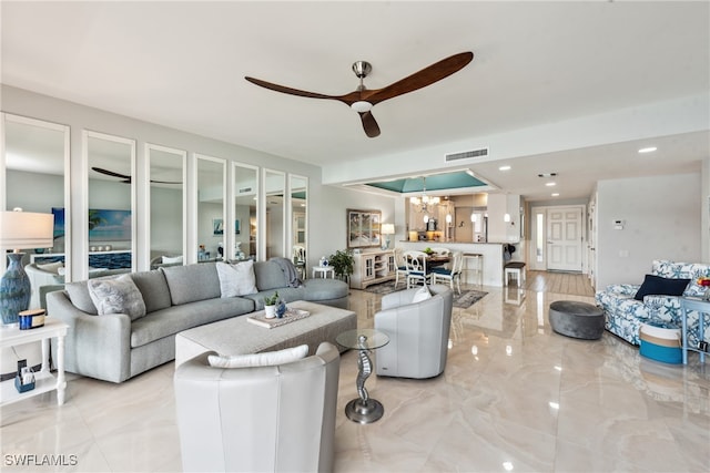 living room featuring ceiling fan with notable chandelier