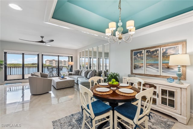 dining room with ceiling fan with notable chandelier, a raised ceiling, and crown molding