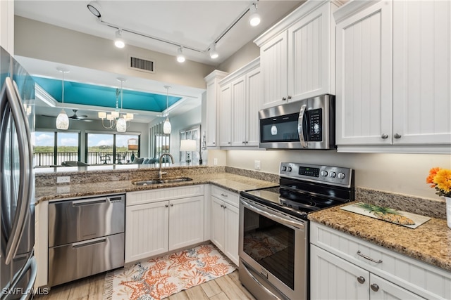 kitchen with sink, ceiling fan, decorative light fixtures, white cabinetry, and stainless steel appliances