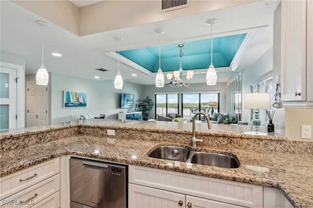 kitchen featuring stainless steel dishwasher, pendant lighting, white cabinetry, and a tray ceiling