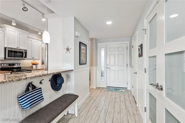 mudroom with light hardwood / wood-style floors and track lighting