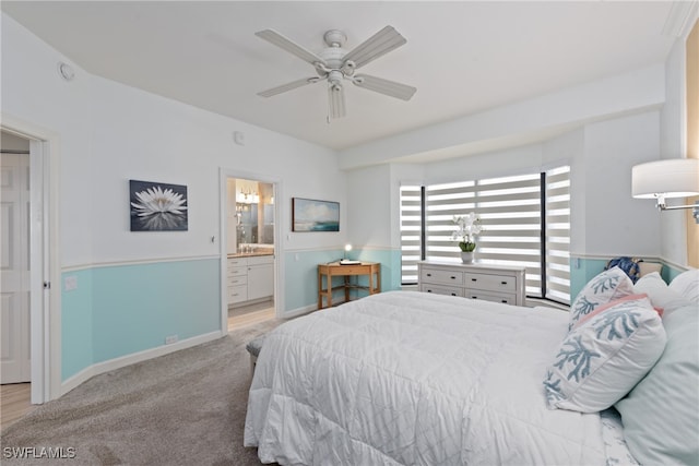 bedroom with connected bathroom, light colored carpet, and ceiling fan