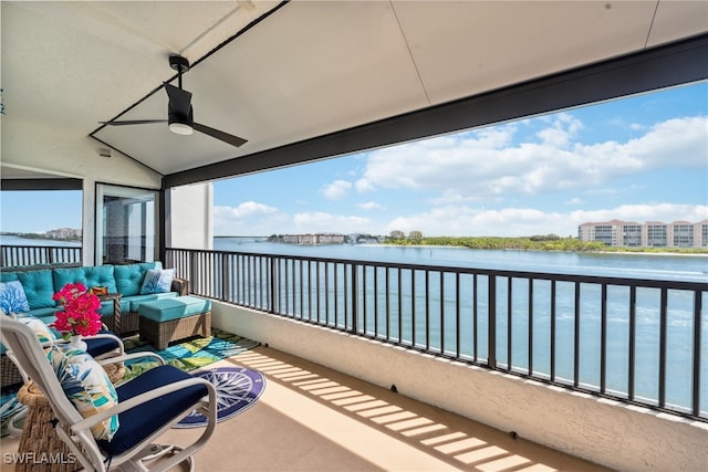 balcony with an outdoor living space, a water view, and ceiling fan