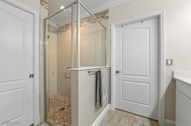 bathroom with vanity, an enclosed shower, and crown molding