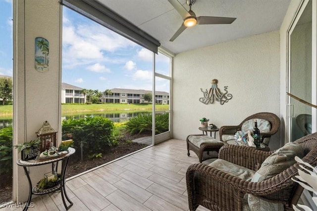 sunroom with a water view and ceiling fan