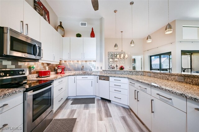 kitchen with appliances with stainless steel finishes, pendant lighting, and white cabinets