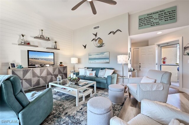 living room with light hardwood / wood-style flooring and ceiling fan