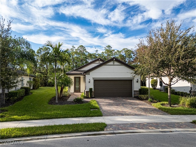 ranch-style home featuring a front lawn, decorative driveway, an attached garage, and stucco siding