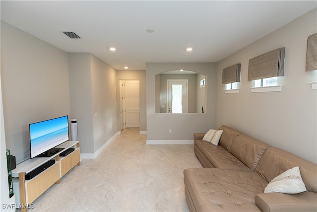 living area featuring recessed lighting, visible vents, arched walkways, and baseboards