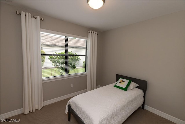 bedroom featuring carpet and baseboards