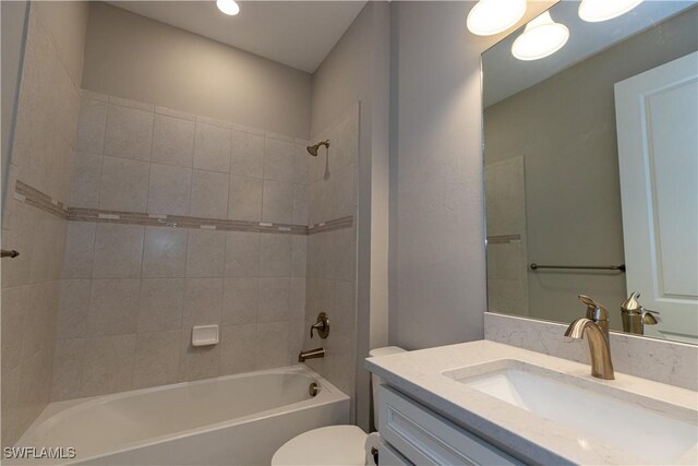 full bathroom with tiled shower / bath combo, vanity, and toilet