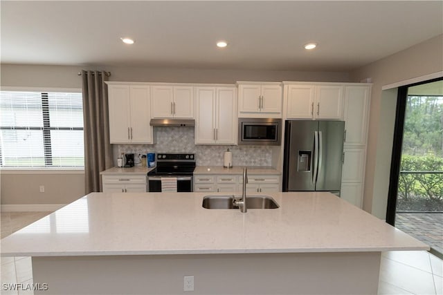 kitchen with sink, stainless steel appliances, light stone counters, white cabinets, and decorative backsplash