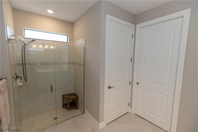 full bath featuring a shower stall and baseboards