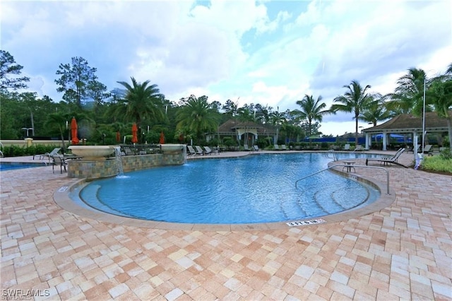 view of swimming pool with a patio, pool water feature, and a gazebo