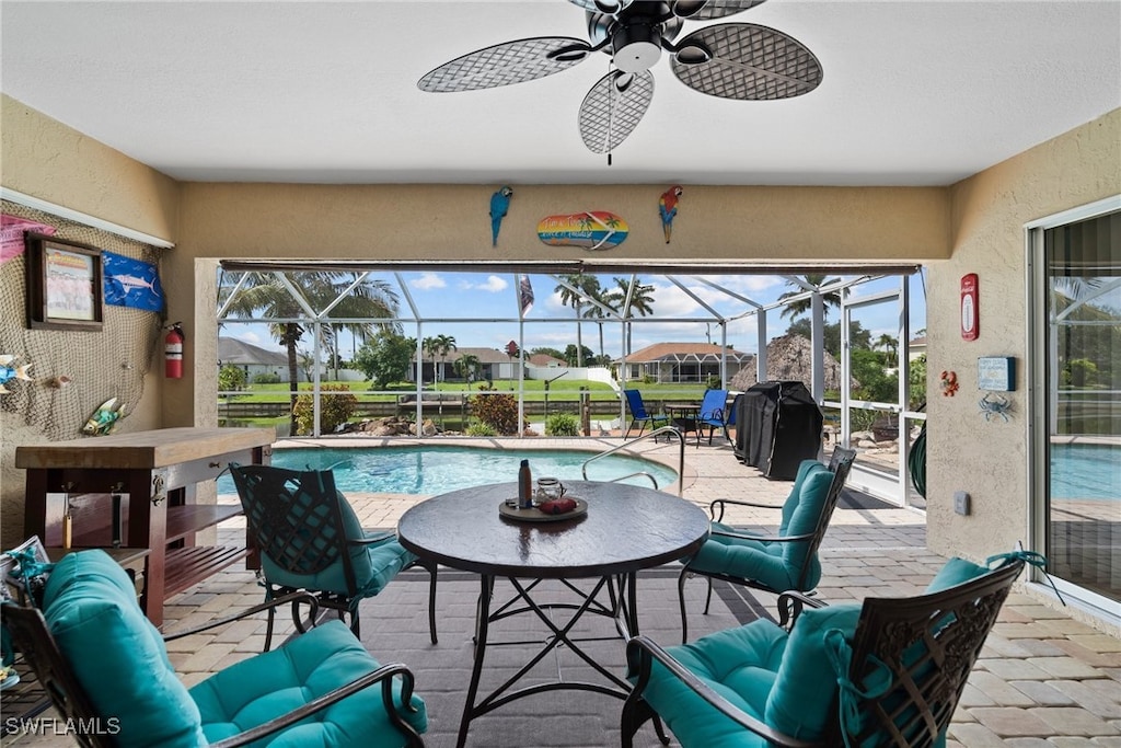 view of patio featuring ceiling fan and glass enclosure