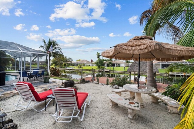 view of patio / terrace featuring a water view and a lanai