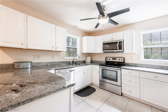 kitchen featuring white cabinets, stainless steel appliances, light tile patterned floors, ceiling fan, and sink