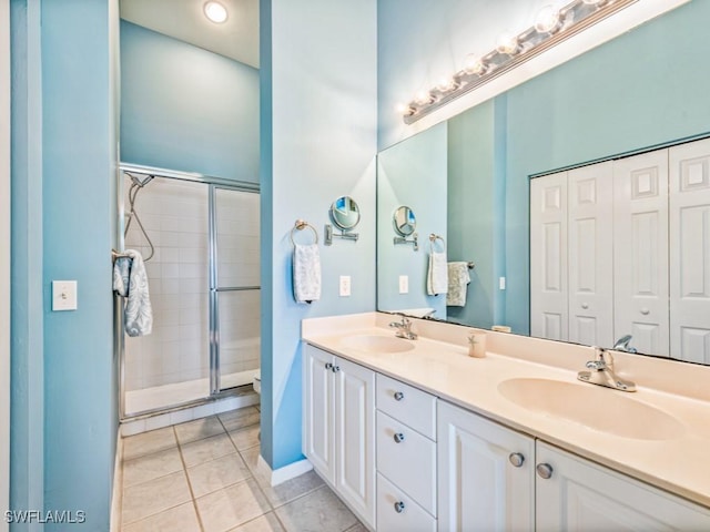 bathroom with an enclosed shower, vanity, and tile patterned floors