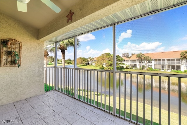 balcony featuring a water view and ceiling fan