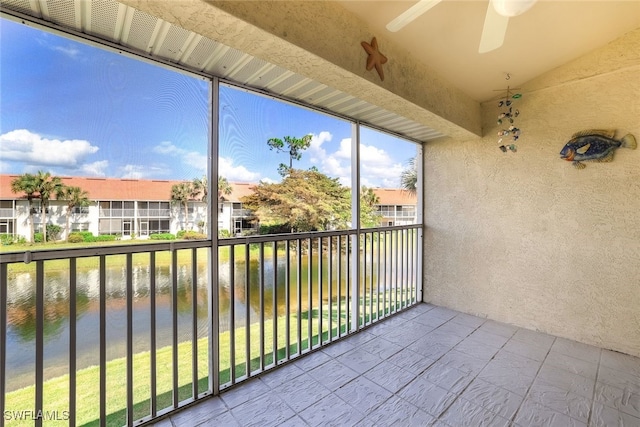 balcony featuring a water view and ceiling fan