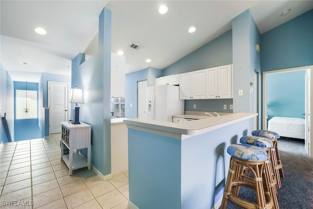 kitchen featuring white fridge with ice dispenser, white cabinets, light tile patterned flooring, vaulted ceiling, and kitchen peninsula