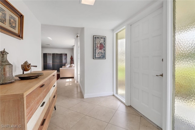 foyer entrance with light tile patterned flooring and baseboards