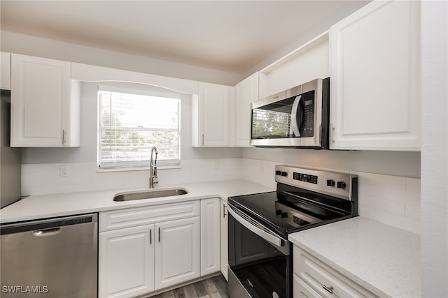 kitchen featuring white cabinets, light wood-type flooring, appliances with stainless steel finishes, and sink