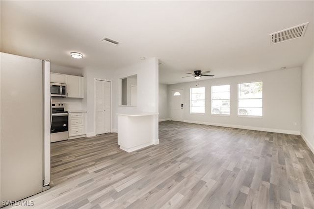 unfurnished living room with light wood-type flooring and ceiling fan