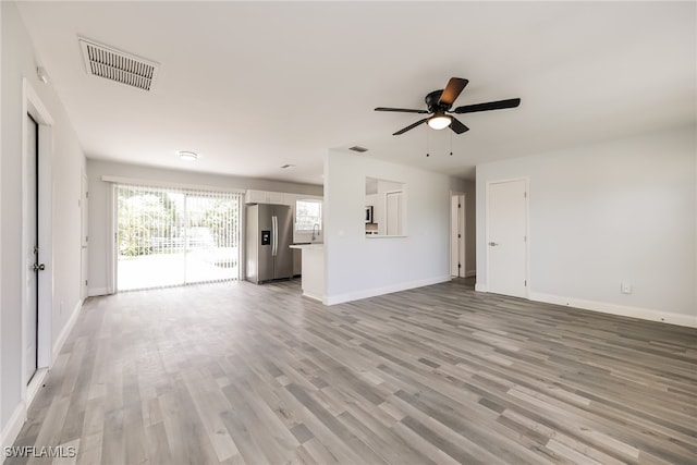 unfurnished living room featuring ceiling fan and light hardwood / wood-style floors