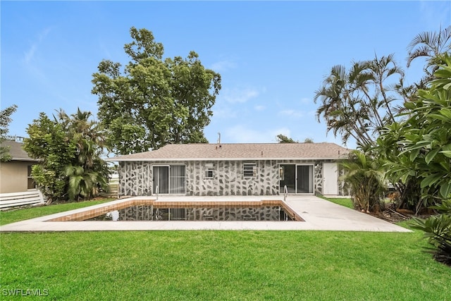 rear view of house with a lawn, a patio, and a sunroom