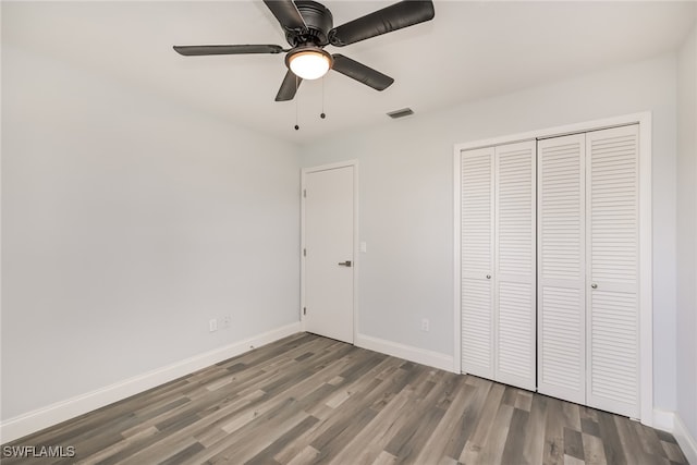 unfurnished bedroom featuring a closet, hardwood / wood-style flooring, and ceiling fan