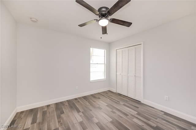 unfurnished bedroom featuring light hardwood / wood-style floors, ceiling fan, and a closet