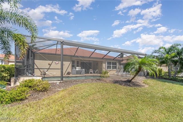 back of property with a yard, a patio, and a lanai