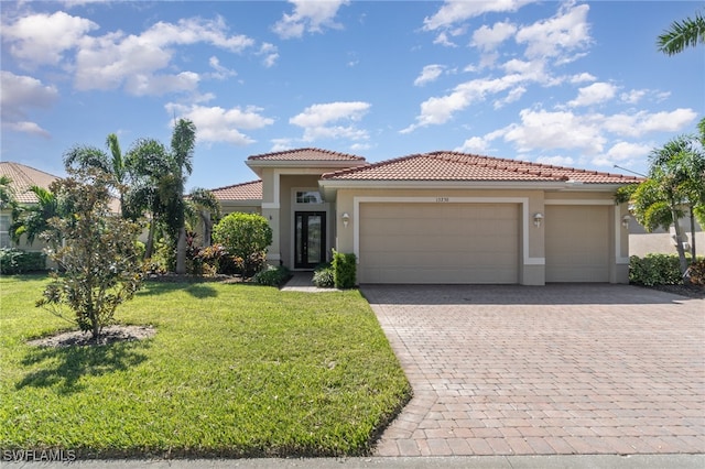 mediterranean / spanish home with a front yard and a garage