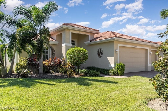 mediterranean / spanish home with a tiled roof, aphalt driveway, a garage, a front yard, and stucco siding