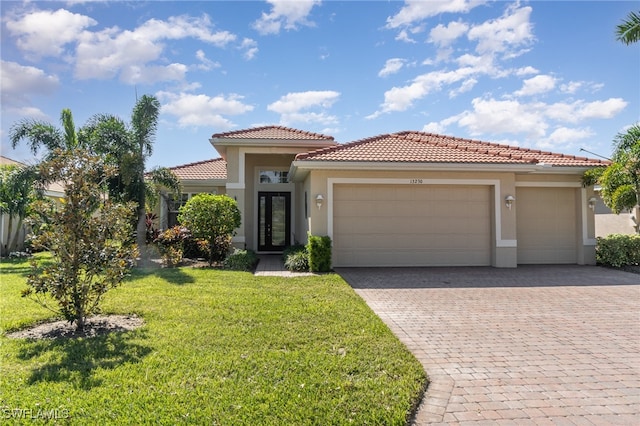 mediterranean / spanish-style home featuring a front lawn and a garage