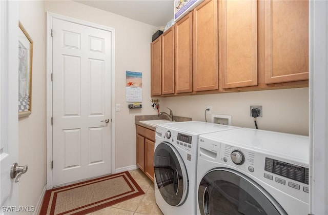 washroom with washer and clothes dryer, light tile patterned floors, a sink, baseboards, and cabinet space