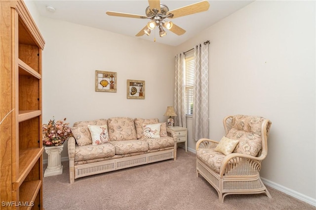 living area featuring carpet, baseboards, and ceiling fan