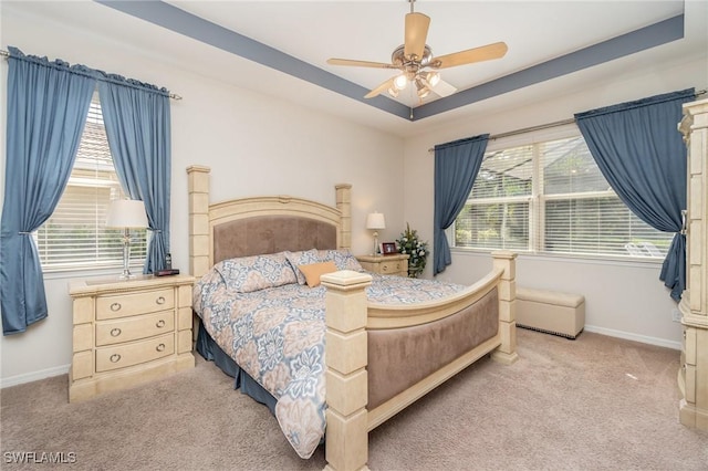 carpeted bedroom featuring baseboards, a ceiling fan, and multiple windows