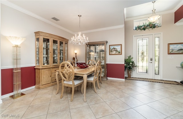 tiled dining room with ornamental molding and a notable chandelier