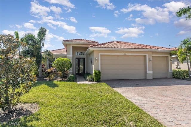 mediterranean / spanish house with a front yard and a garage