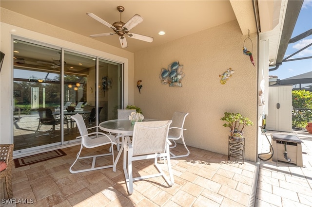 view of patio featuring ceiling fan and glass enclosure